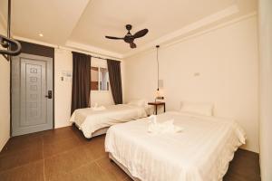 长滩岛Hotel Gray in Boracay的一间卧室配有两张床和吊扇
