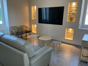 Veneux-les-SablonsMAISON VENEUX LES SABLONS-FONTAINEBLEAU-MORET SUR LOING的客厅配有沙发、椅子和电视