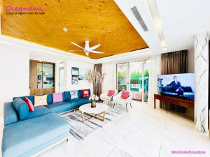 隆海Villa 1602 Oceanami, Sát biển, Hồ bơi riêng, 837m2的客厅配有蓝色的沙发和平面电视。