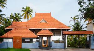 奎隆Kalloos Island Backwater Resort的一座种植了棕榈树的橙色屋顶房子