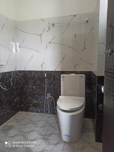 索拉哈Hotel Namo Buddha的一间位于客房内的白色卫生间的浴室