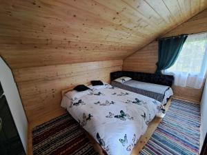 博尔沙CABANA MERISORULUI的小木屋内一间卧室,配有一张床