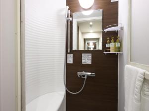 广岛Dormy Inn Hiroshima Annex的带淋浴、水槽和镜子的浴室