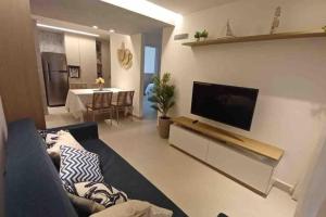 塔曼达雷Residencial Taormina - apartamento à beira-mar novinho!的带沙发和平面电视的客厅