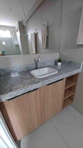 塔曼达雷Residencial Taormina - apartamento à beira-mar novinho!的一间带水槽和镜子的浴室