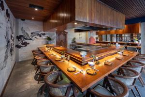 德格拉朗Aksari Resort Ubud by Ini Vie Hospitality的餐厅里一张长木桌子和椅子