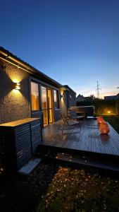 马鲁佩ULU House With Terrace & Hot Tub的木甲板上设有长凳和野餐桌