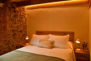 莱昂El Molino de Nocedo的一间卧室配有一张带白色床单和两盏灯的床。