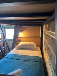 素叻2street Hostel的一间带床的卧室,位于带梯子的房间