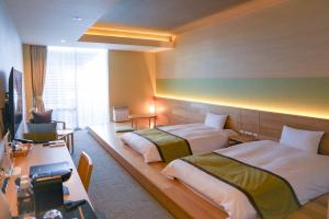 热海ISHINOYA Atami的酒店客房配有两张床和一张书桌