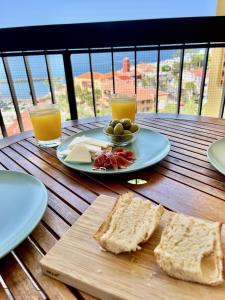 法纳贝海滩Lookout Point Tenerife Holiday Apartment Las Americas的一张桌子,上面放着一盘面包和两杯橙汁