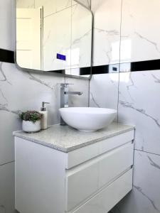 奥克兰Santos Place的浴室设有白色水槽和镜子