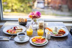 隆德First Hotel Planetstaden的餐桌,包括早餐食品和橙汁盘