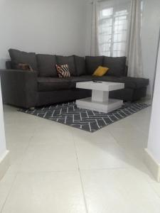 ThikaCarlyle comfort home的带沙发和咖啡桌的客厅