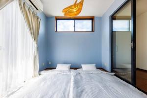读谷村Yomitan kuba house的一间卧室设有一张蓝色墙壁的大床