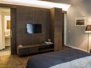 派尔努Studio28 Boutique Rooms的一间卧室配有一张床,墙上配有电视