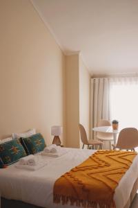 埃斯平霍44 Forty Four Coast - Espinho的卧室配有一张床和一张桌子及椅子