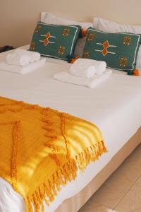 埃斯平霍44 Forty Four Coast - Espinho的床上有毛巾和黄色的毯子