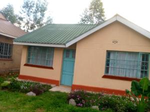 基苏木Pelia Rose Guesthouse的绿色屋顶和蓝色门的房子