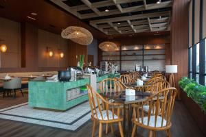 雅加达阿维撒套房酒店的一间带木椅和桌子的餐厅以及柜台