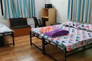纳西克1BK Comfy & Budget Friendly Stay的小房间设有一张床和一把椅子