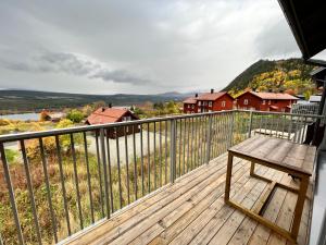 菲奈斯达伦Salmons väg Funäsdalen的阳台上的木甲板上设有长凳