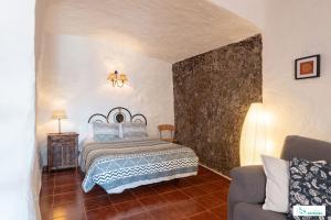 阿尔特纳拉Living Artenara - CAVE HOUSE & TERRACE Adults Only的一间卧室配有一张床和一张沙发