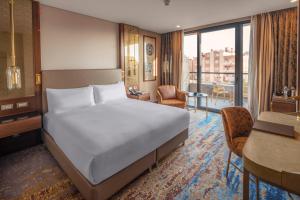 安塔利亚Doubletree By Hilton Antalya City Centre的一间卧室配有一张床,客厅配有书桌