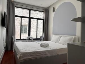 胡志明市Moka's House的一间卧室设有一张床和一个大窗户