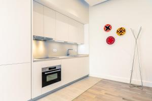 塞维利亚Magno Apartments Casa del Correo Mayor II的厨房配有白色橱柜和冰箱。
