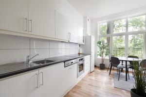 奥斯陆Grünerløkka Deluxe Apartments的白色的厨房配有水槽和桌子