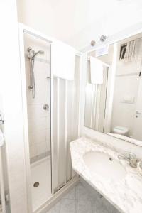 里米尼Hotel Saint Louis的带淋浴和盥洗盆的白色浴室