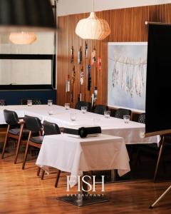 GjakoveHOTEL 12的用餐室配有桌椅和白色桌布