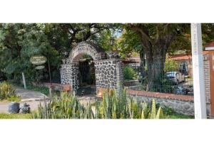 查帕拉Capital O Posada Del Pescador的公园内有树的石拱门