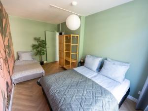 鹿特丹Rotterdam's coolest apartment的一间卧室设有两张床和书架