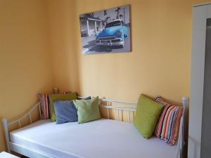 萨尔布吕肯瑙维瑟公寓式酒店的卧室配有一张床铺,墙上挂着一辆旧车