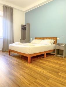 罗马Lexie Suites的铺有木地板的客房内一张大床