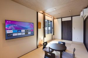 箱根スタジオーネ箱根彫刻の森的一间墙上配有电视的用餐室