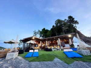甲米镇7 Heaven camping Lanta的拥有蓝白色椅子的度假村和一座建筑