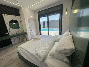 杰里科 alzain 2 villas فلل الزين ٢的一间卧室设有一张床,享有游泳池的景色