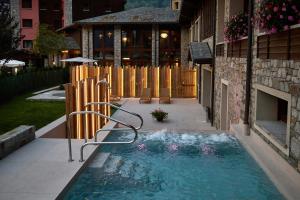 蓬泰迪莱尼奥阿克夸西亚蓝色酒店的一座游泳池,位于一座建筑旁的院子内