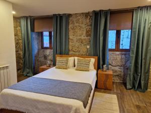吉尔斯Quinta da Casa dos Santos - Inside Gerês的一间卧室配有一张带绿色窗帘的大床
