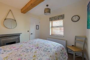 圣安德鲁斯Country Cottage by St. Andrews的卧室配有一张床,墙上挂着一个钟