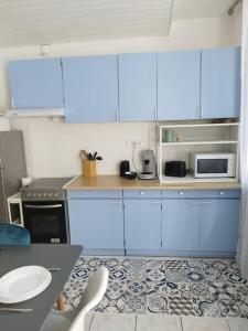 勒阿弗尔Maison atypique avec garage 2 roues - Proche Gare的厨房配有蓝色橱柜和桌椅