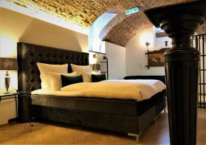 弗莱堡Historical Luxury Homes - Stadtvilla的一间卧室配有一张大床和黑色床头板