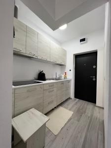 Ocna-MureşuluiLa Luna Imobiliare的厨房配有白色橱柜和黑色门