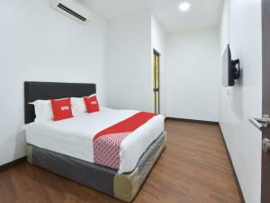 雪邦OYO 90869 Hotel Madeena Inn的一间卧室配有红色枕头的床