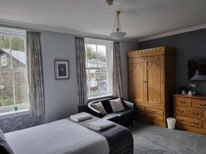 鲍内斯温德米尔费尔维欧旅馆的一间卧室配有一张床、一个橱柜和一把椅子