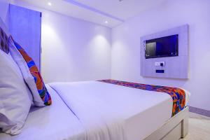 孟买FabExpress Embassy Suites的白色的客房配有床和电视。