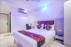 孟买FabExpress Embassy Suites的一间卧室配有一张大床和色彩缤纷的被子